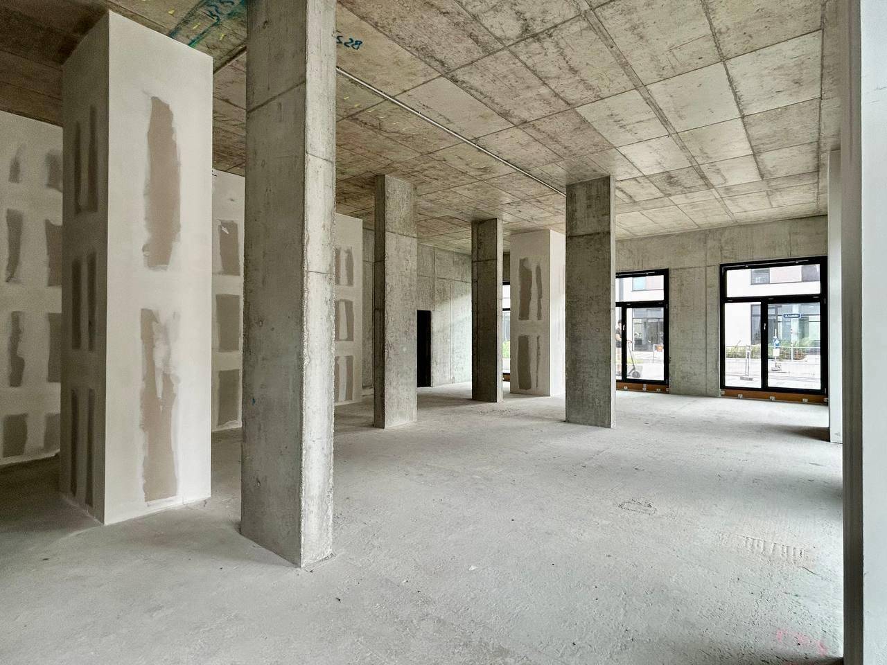 Großer Rohbau-Innenraum mit zahlreichen Betonstützen und vorbereiteten Wandflächen.