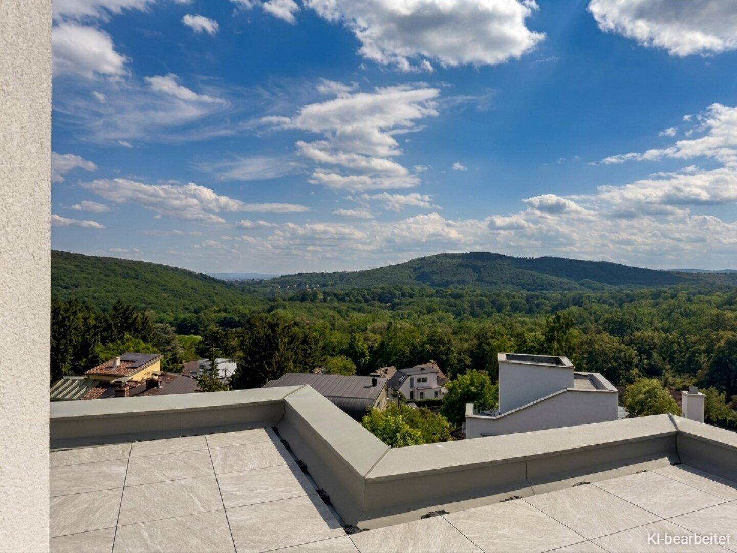 Großzügige Dachterrasse mit Fliesenboden und weitem Blick über die grüne Hügellandschaft.