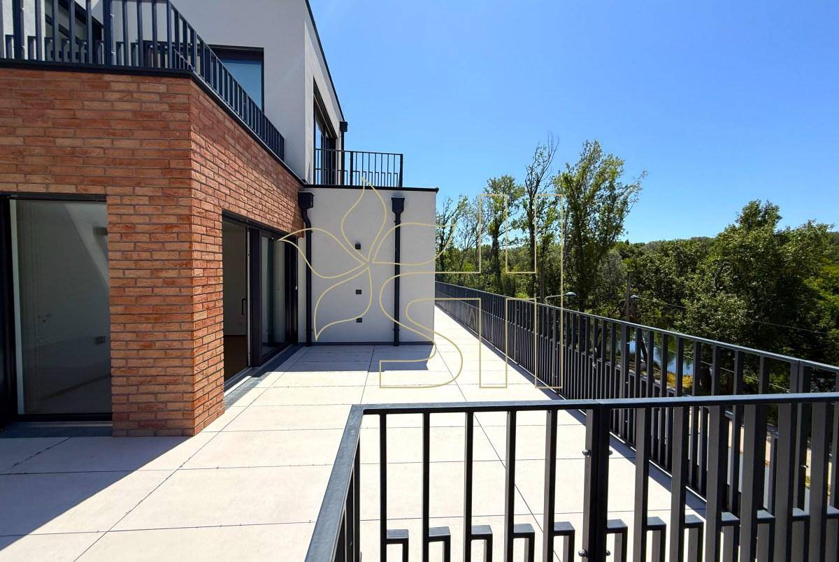 Weitläufige Terrasse mit modernem Geländer und Ziegelfassade, bietet einen schönen Blick auf die grüne Umgebung.