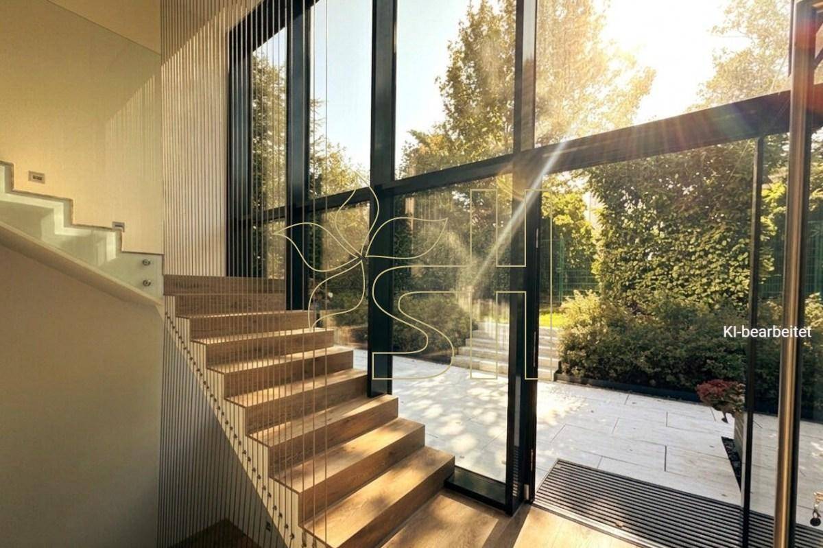 Modernes Treppenhaus mit Holzstufen und raumhohen Fenstern, die viel Licht hereinlassen.