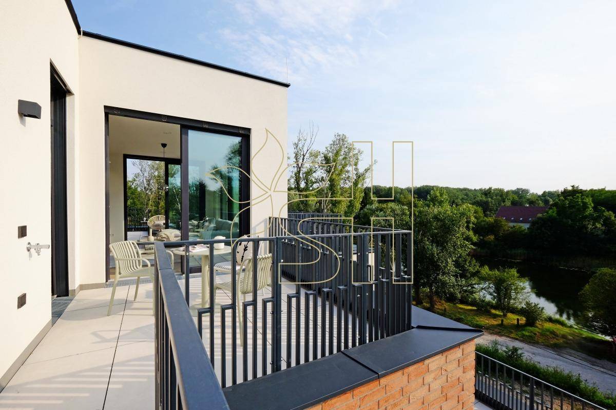 Geräumige Terrasse mit modernem Geländer und weitem Blick auf die umliegende Natur und einen See.