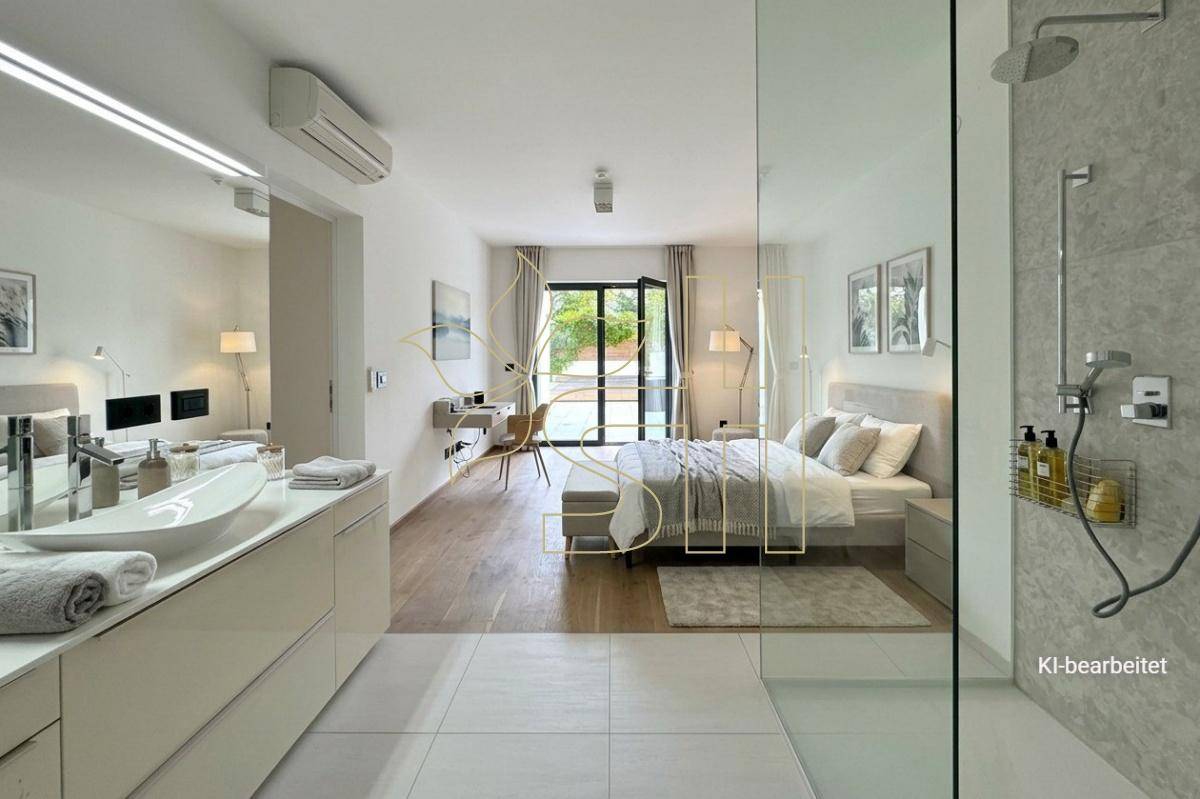 Helles Schlafzimmer mit direktem Zugang zum modernen Badezimmer und Blick ins Grüne.