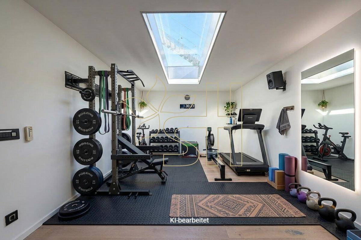 Gut ausgestatteter Fitnessraum mit Trainingsgeräten, Gummiboden und großem Dachfenster.