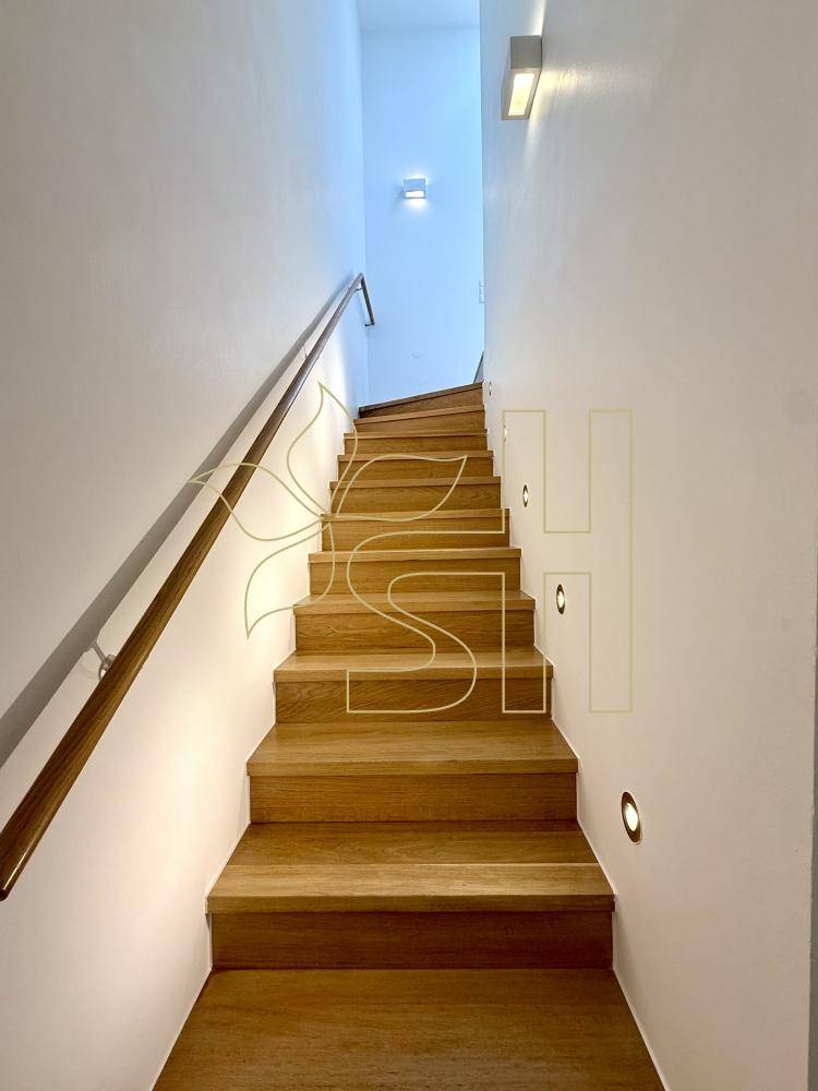 Elegante Holztreppe mit modernem Handlauf und integrierter Beleuchtung an den Stufen.