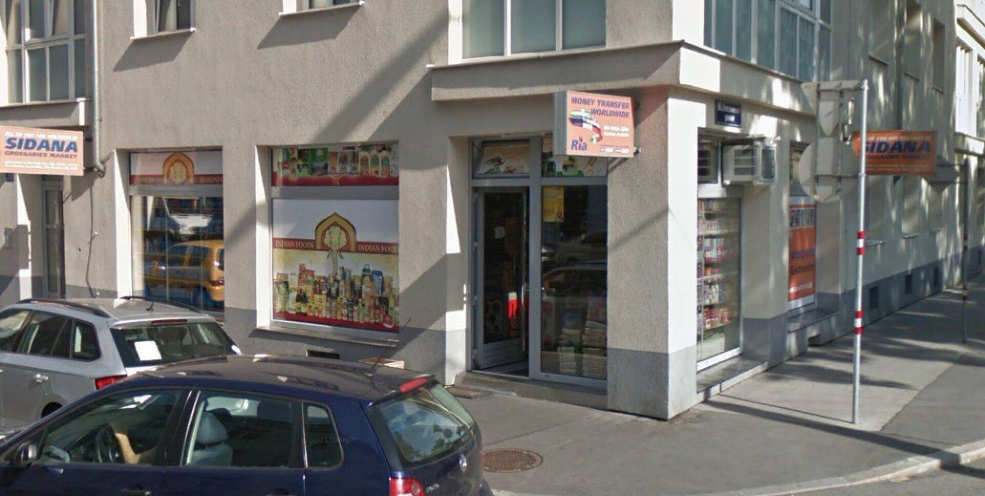 Eckgebäude mit mehreren Schaufenstern und einem Eingang zu einem Geschäft an der Straße.