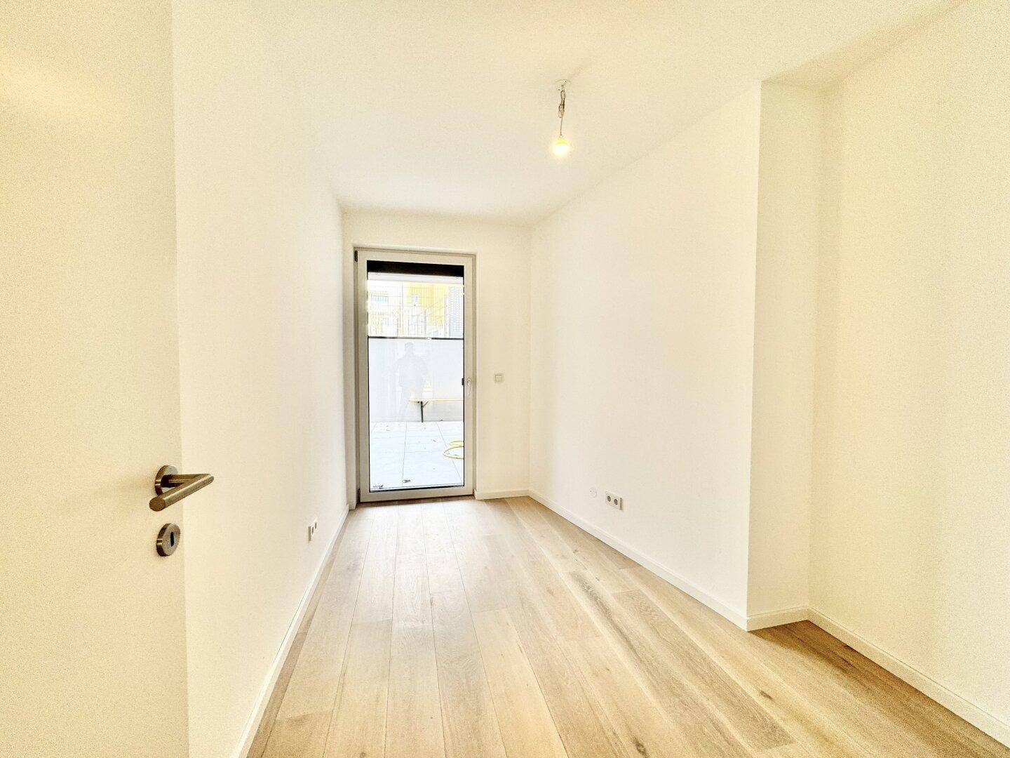Ruhiges Zimmer mit Holzboden und Tür zu einem privaten Außenbereich.