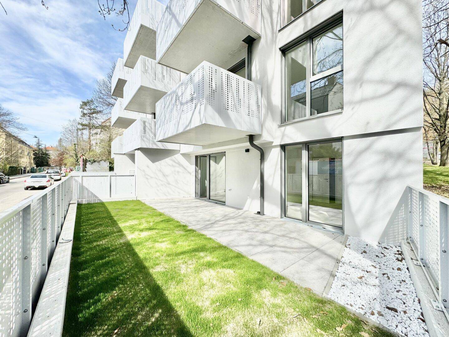 Moderne Wohnanlage mit Balkonen und einer Erdgeschosswohnung mit privatem Garten und Terrasse.