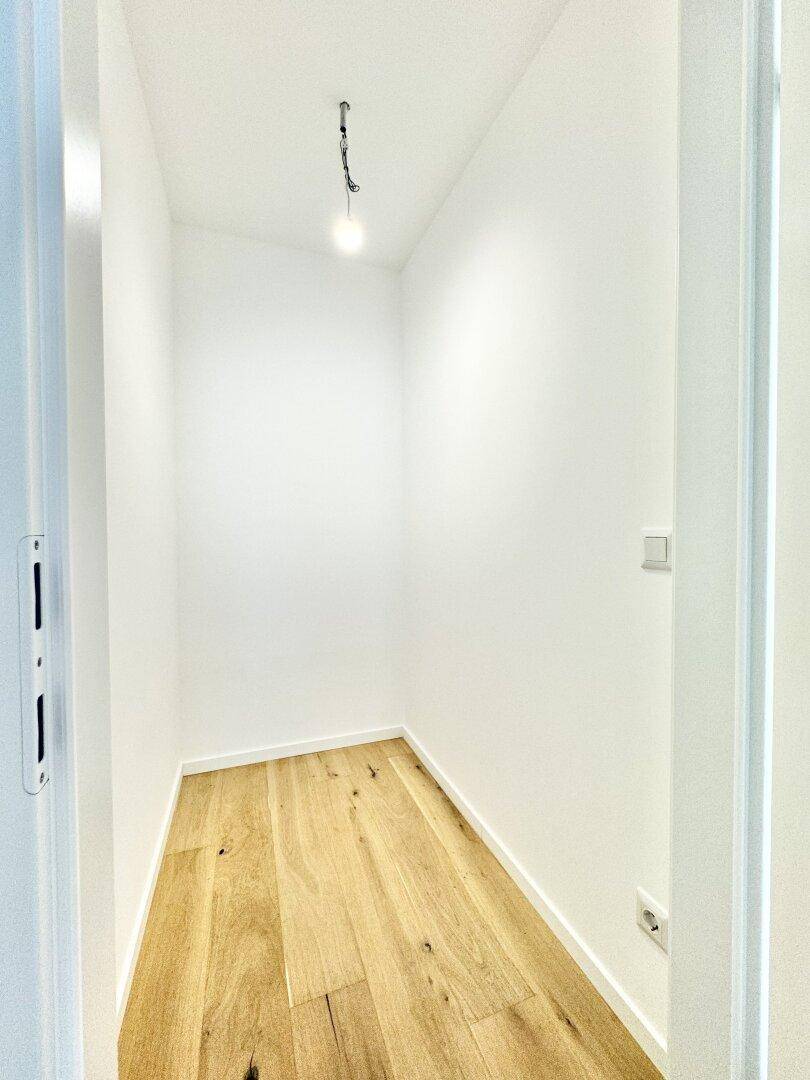 Kleiner Abstellraum mit Holzboden und weißen Wänden, ideal für zusätzlichen Stauraum.