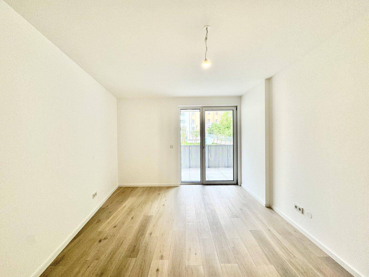 Helles Schlafzimmer mit Holzboden und direktem Zugang zu einem privaten Balkon.