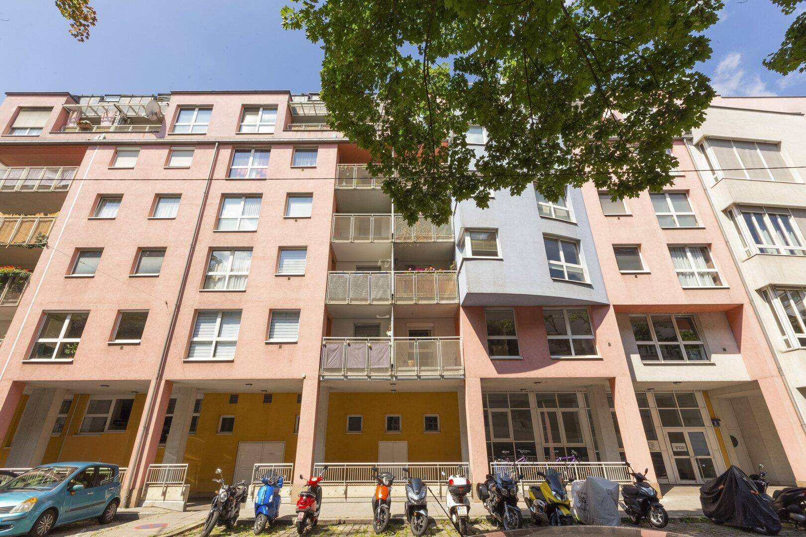 Wohngebäude mit farbenfroher Fassade, Balkonen und modernen architektonischen Elementen.