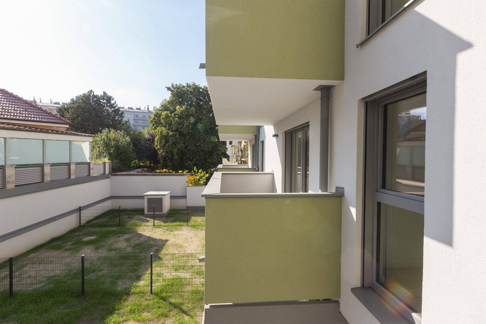 Balkone mit grünen Brüstungen und Blick auf den Gemeinschaftsgarten.