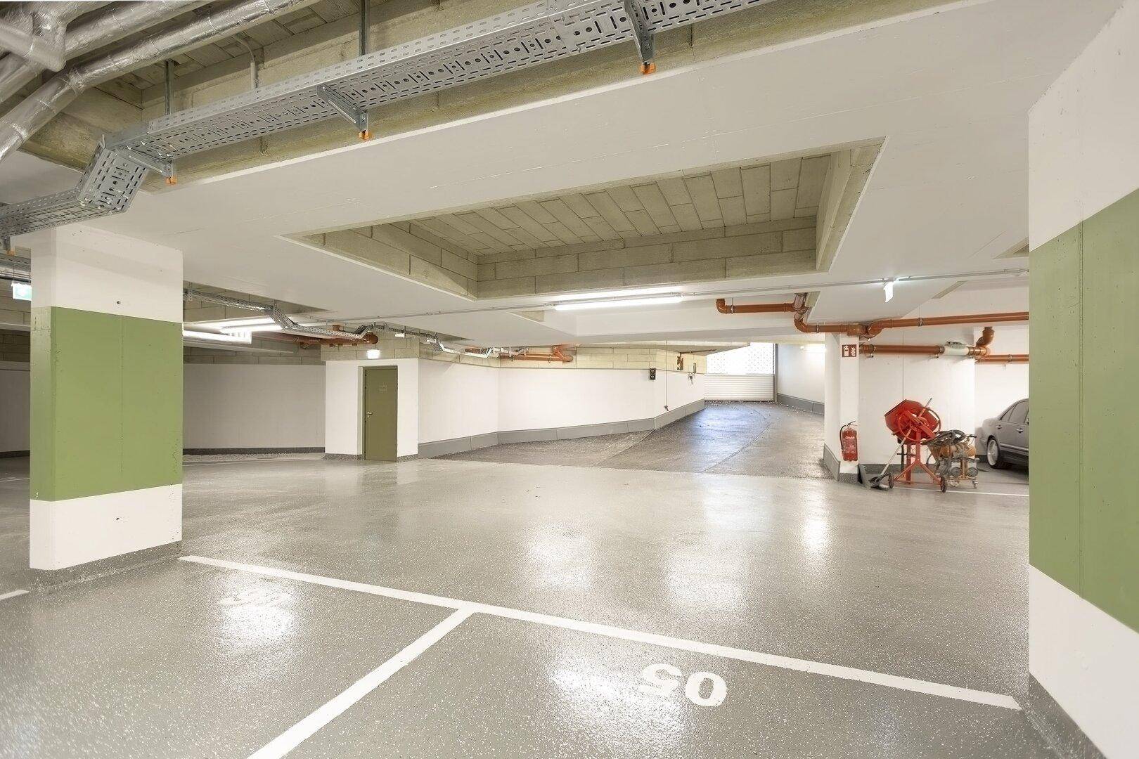 Geräumige Tiefgarage mit markierten Stellplätzen und guter Beleuchtung.