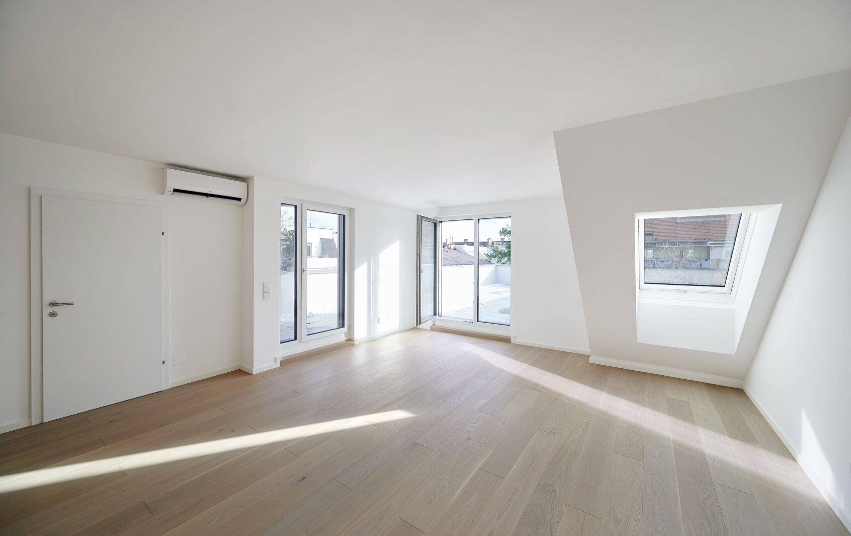 Lichtdurchfluteter Raum mit Holzboden, Dachfenstern und Klimaanlage, bereit zum Einzug.