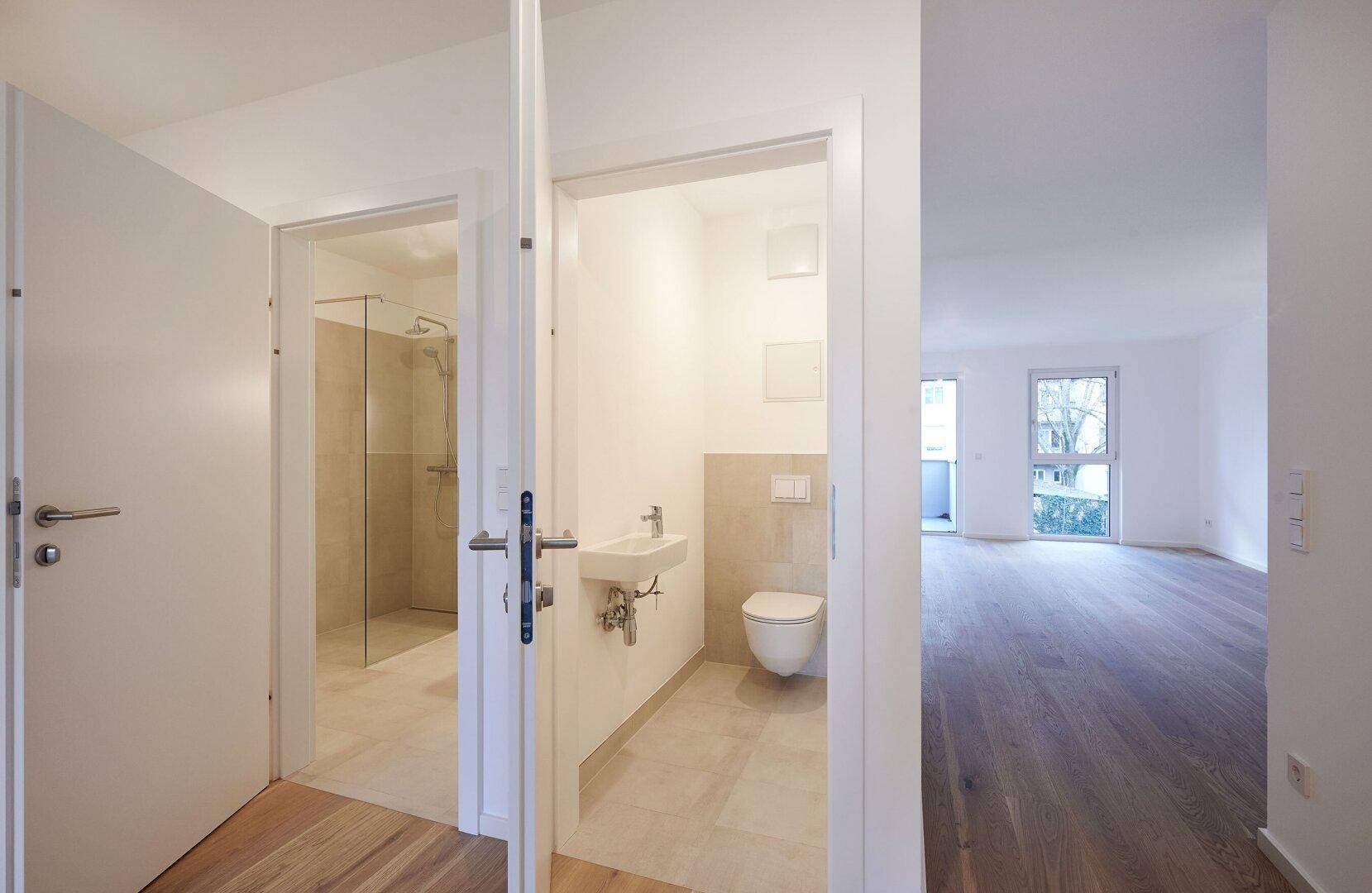 Moderner Flur mit Zugang zu einem Gäste-WC und einem Badezimmer mit Dusche.