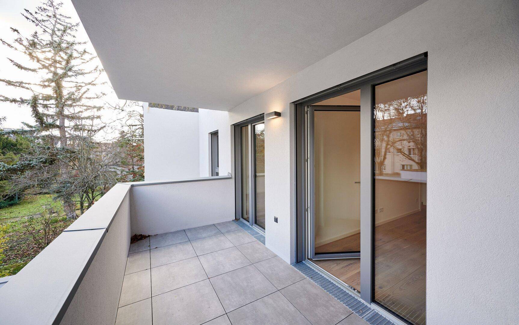 Geräumiger Balkon mit Fliesenboden und Blick ins Grüne, ideal zum Entspannen.