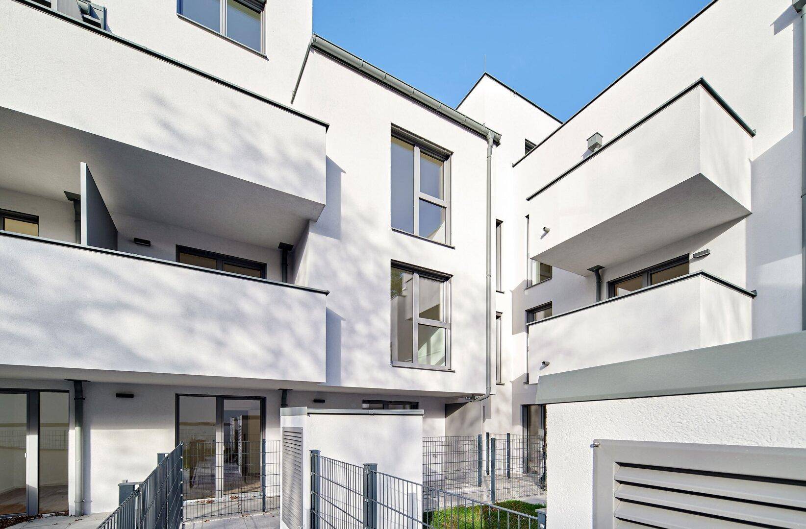 Detailansicht der modernen Fassade mit klaren Linien und mehreren Balkonen.