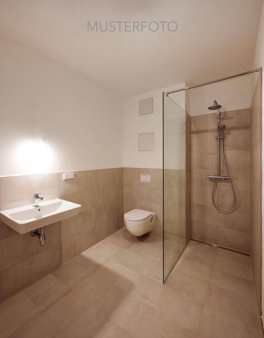 Modernes Badezimmer mit begehbarer Dusche, Wand-WC und hellem Fliesenboden.