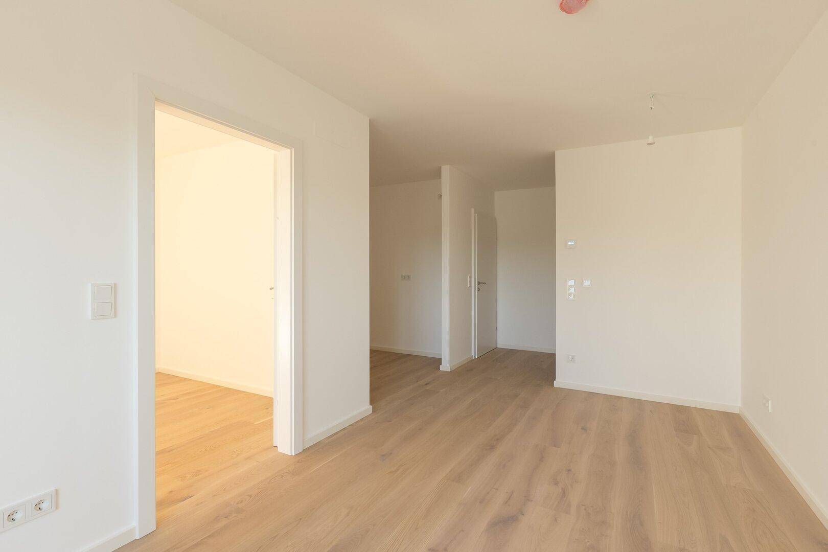 Heller Flur mit Holzboden, der zu verschiedenen Räumen führt und einladend wirkt.