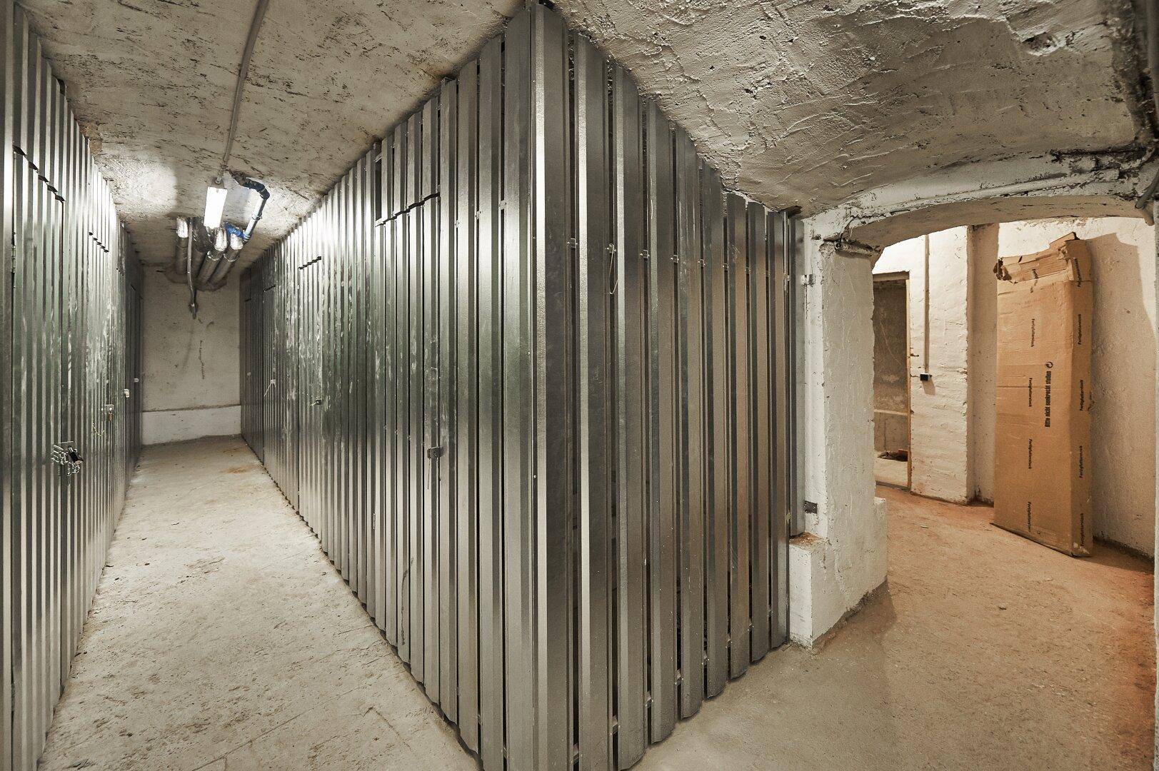 Kellerraum mit Metallabtrennungen für individuelle Lagerbereiche, in einem funktionalen Zustand.