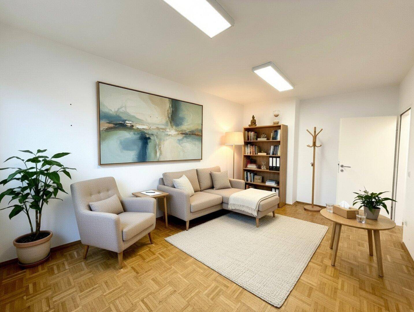 Gemütlicher Wartebereich mit beigem Sofa, Sessel, Bücherregal und hellem Parkettboden.