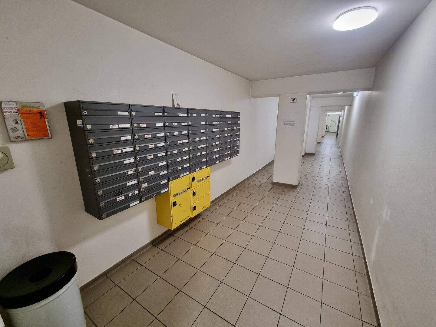 Gemeinschaftlicher Flur mit Briefkästen und hellem Fliesenboden im Eingangsbereich.