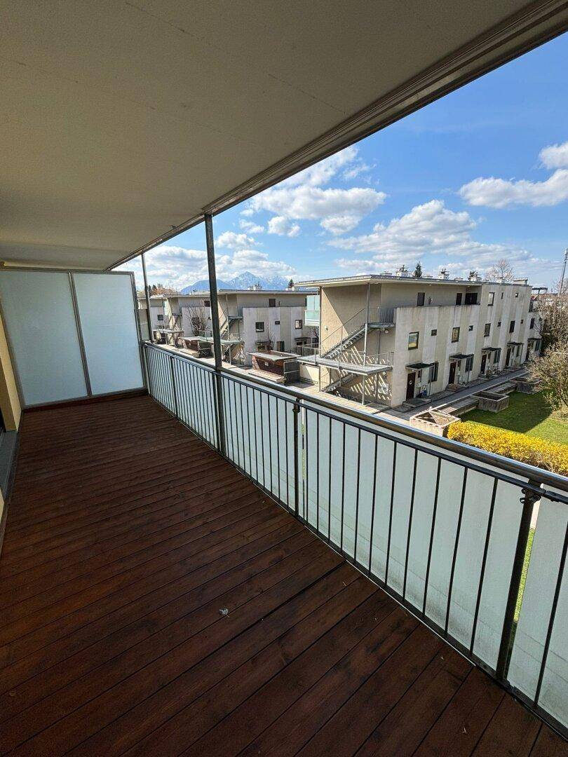 Geräumiger Balkon mit Holzboden und Bergblick, perfekt für entspannte Stunden im Freien.