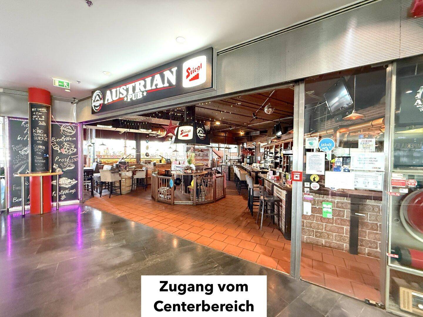Zugang zum Restaurant vom Centerbereich aus, mit Schiebetüren und Blick in den belebten Gastraum.