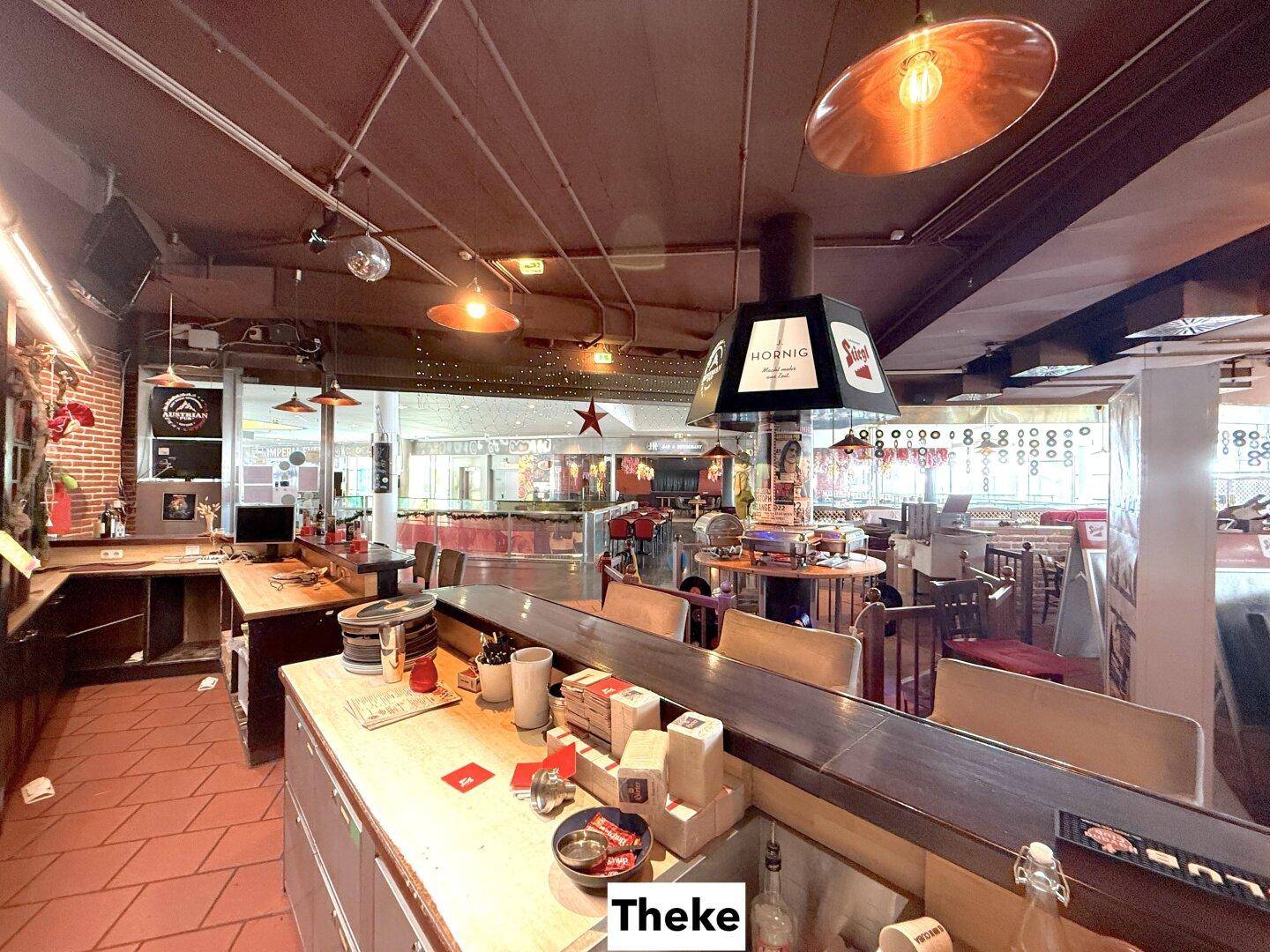 Thekenbereich mit Arbeitsflächen, Spülbecken und Regalen, bereit für den Service in der Gastronomie.