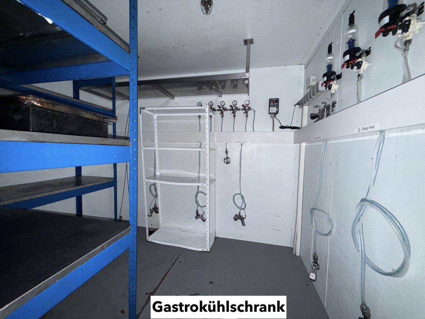 Innenansicht eines Gastro-Kühlraums mit Regalen und Zapfanlagen, optimiert für Getränkelagerung.