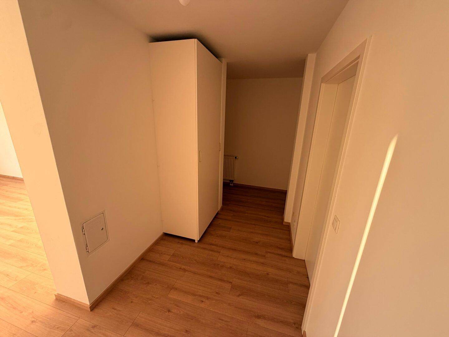 Heller Flurbereich mit Laminatboden und praktischem Einbauschrank, der viel Stauraum bietet.