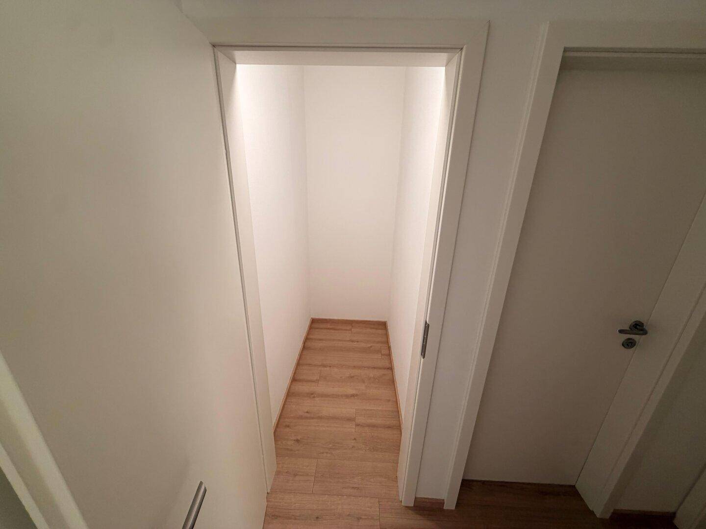 Praktischer Abstellraum mit Laminatboden und weißen Wänden, ideal für zusätzlichen Stauraum.