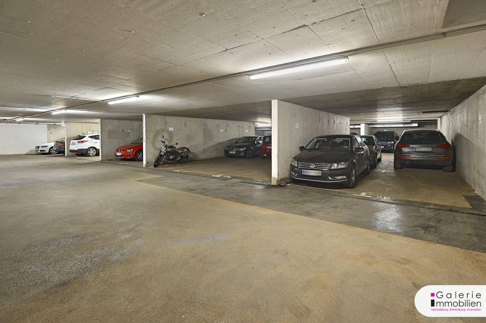 Geräumige Tiefgarage mit Betonwänden und -decken, bietet Stellplätze für mehrere Fahrzeuge.