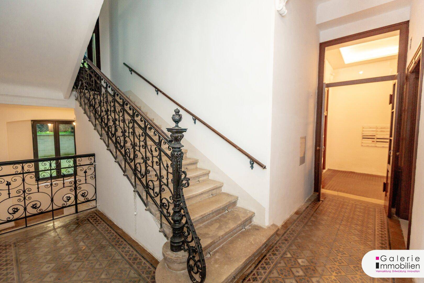 Historisches Treppenhaus mit Marmorstufen und kunstvollem schmiedeeisernem Geländer.
