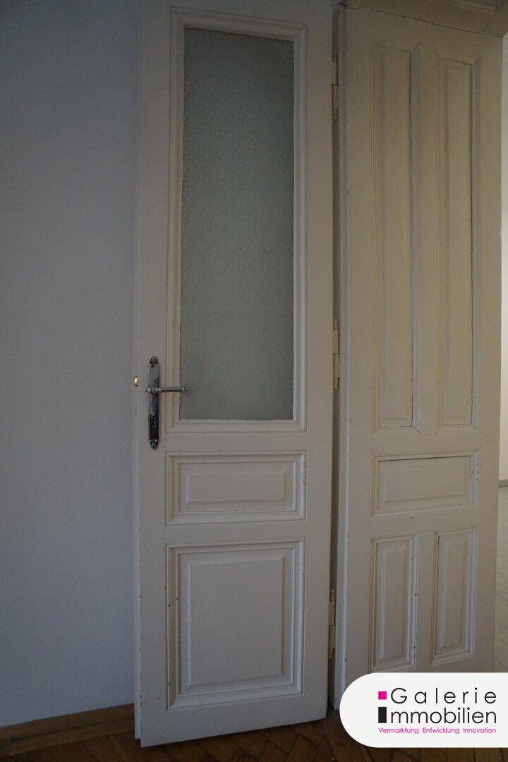 Klassische weiße Innentür mit Glaseinsatz und traditionellem Design.