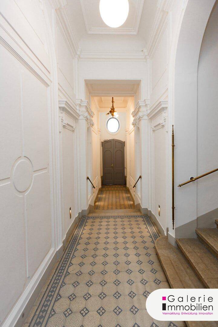 Eleganter Eingangsbereich mit gemusterten Fliesen, hohen Decken und klassischer Architektur.