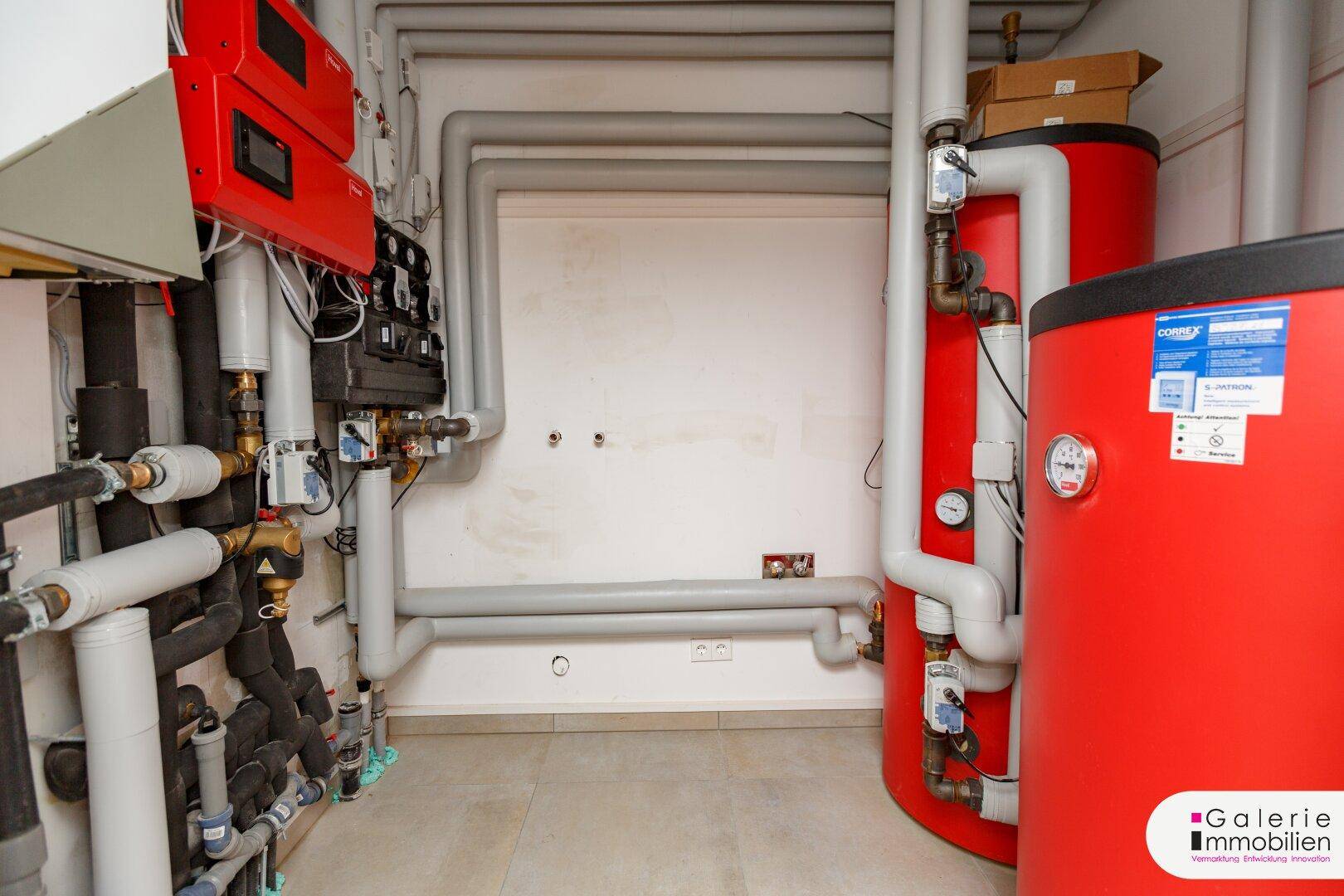 Technikraum mit Heizungsanlage und Warmwasserspeichern, gut zugänglich und organisiert.