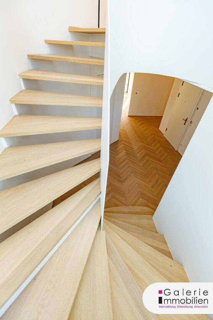 Detailansicht der modernen Holzwendeltreppe mit minimalistischem Design und hellem Ambiente.