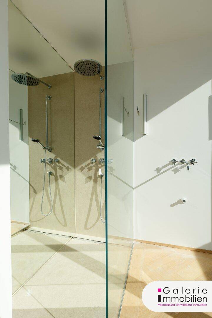 Moderne Duschkabine mit zwei Regenduschen und minimalistischem Design.