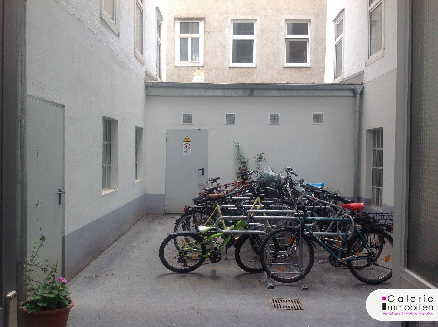 Innenhof eines Wohngebäudes mit Fahrradabstellplätzen und schlichter Gestaltung.