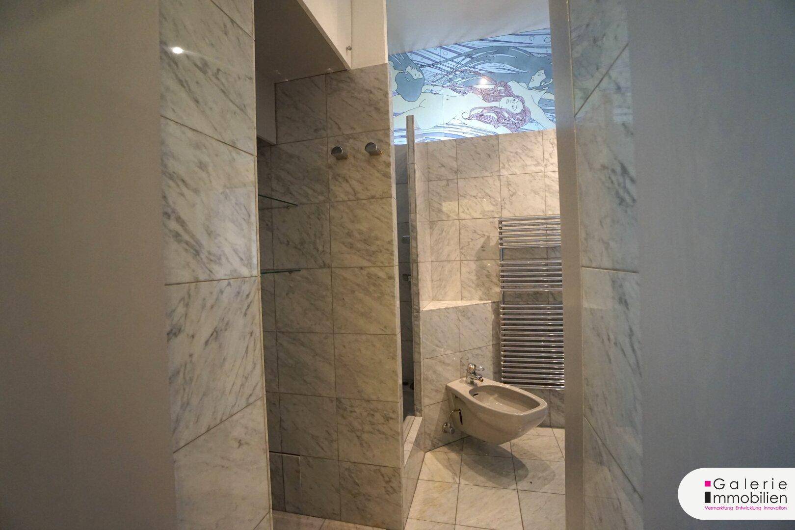 Gefliester Bereich im Badezimmer mit Bidet und beheiztem Handtuchhalter.