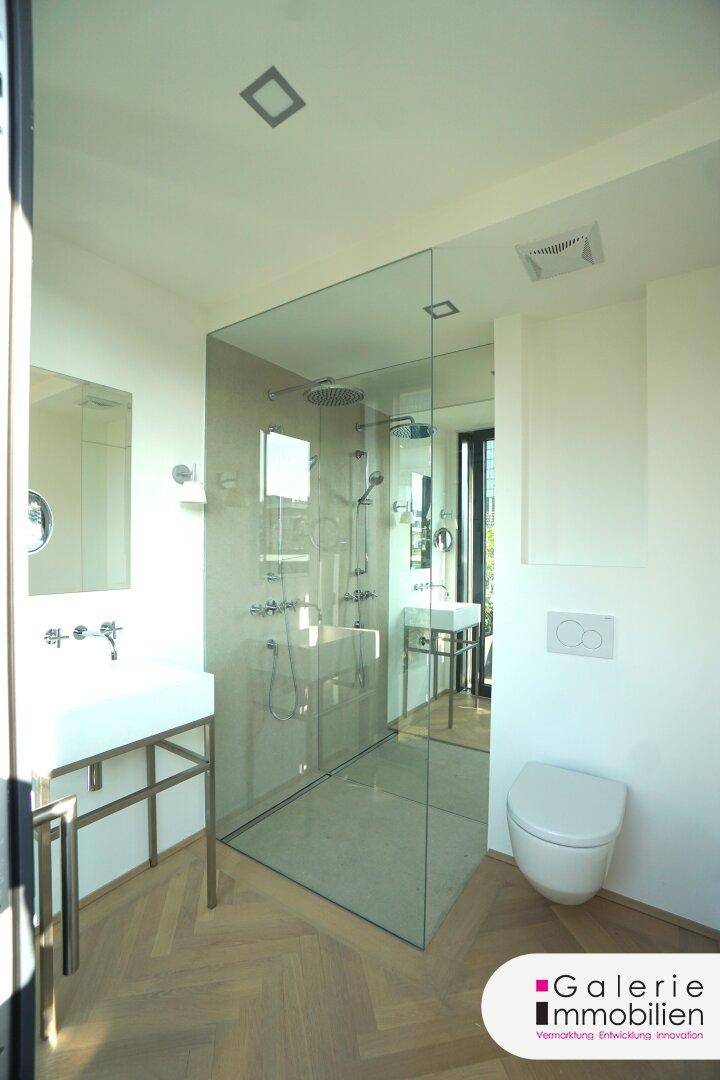Helles Badezimmer mit begehbarer Glasdusche, modernem Waschbecken und Wand-WC.