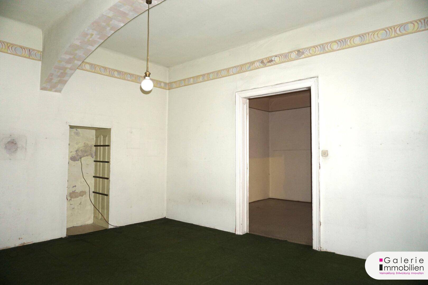 Unmöblierter Raum mit Teppichboden und einer Nische, die auf eine Neugestaltung wartet.