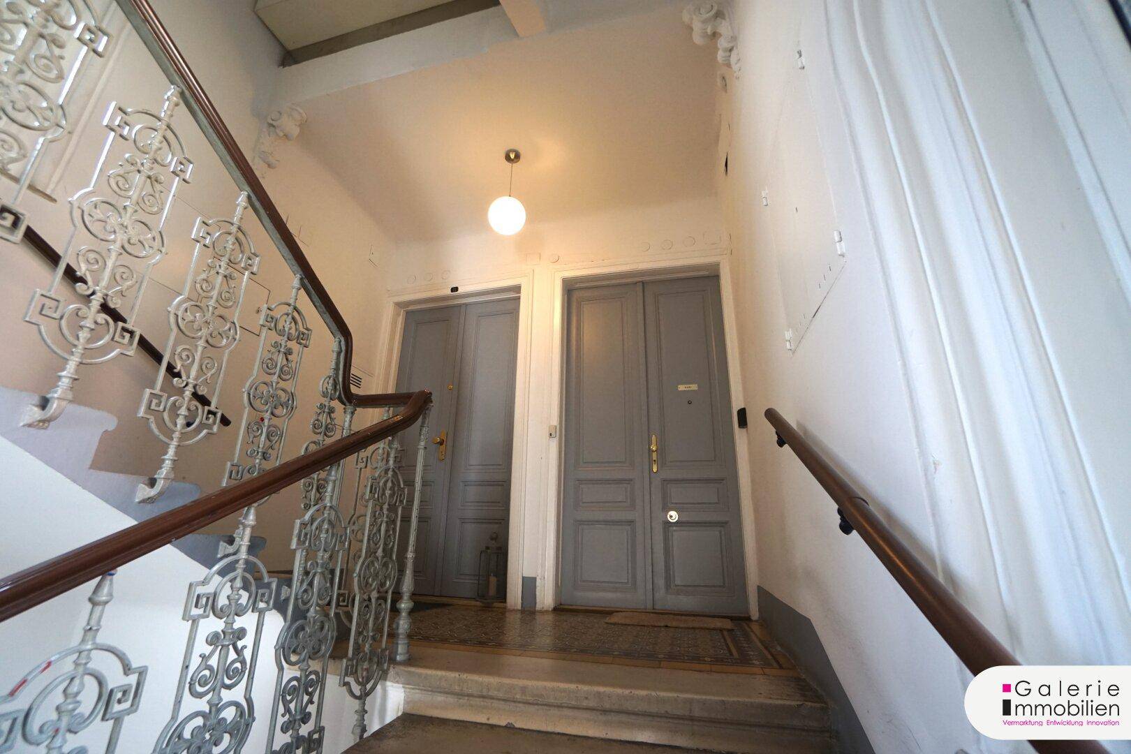 Historisches Treppenhaus mit kunstvollem Geländer und Zugang zu den Wohneinheiten.