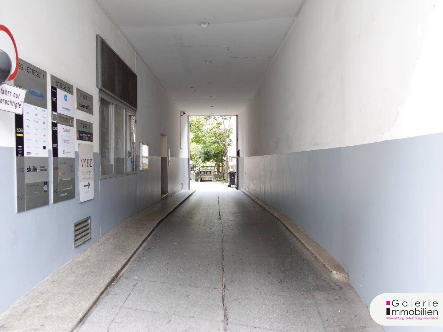 Zufahrtsrampe zum Gebäude mit Hinweisschildern an der Wand.