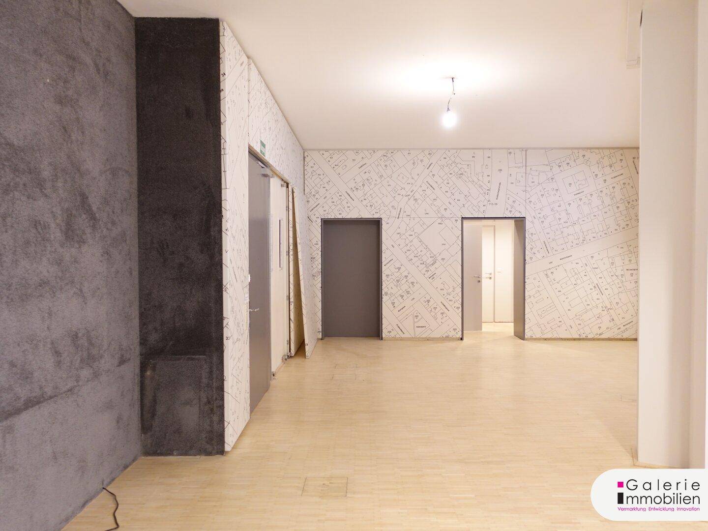 Heller, leerer Raum mit Holzboden und modernen Wandverkleidungen.