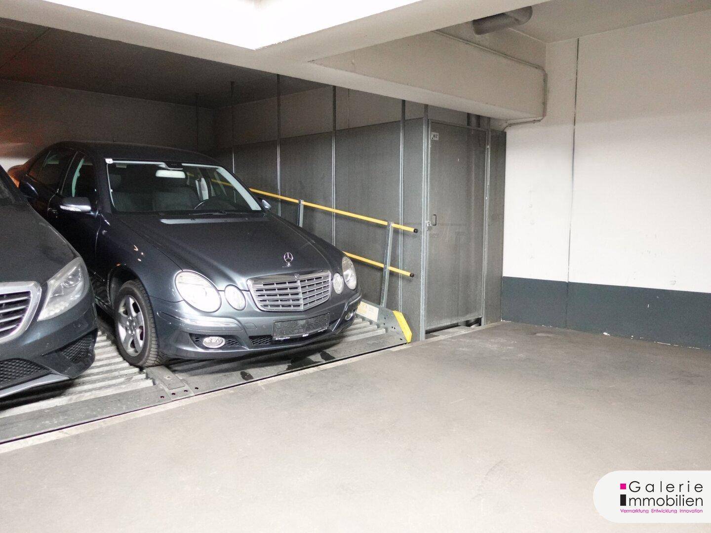 Tiefgarage mit mechanischem Doppelparker-System, das ein Fahrzeug auf der oberen Plattform zeigt.