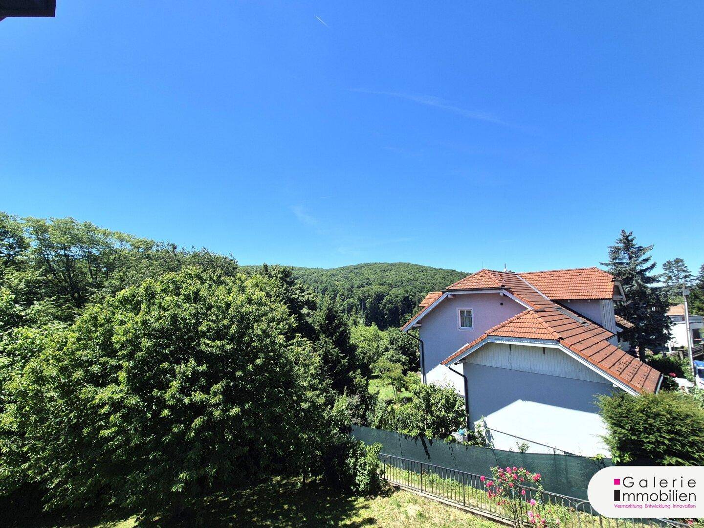 Weitläufiger Blick über grüne Hügel und die umliegende Landschaft an einem sonnigen Tag.