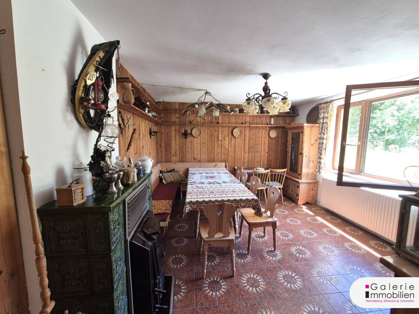 Rustikaler Essbereich mit Holztäfelung, Kachelofen und traditionellen Möbeln.