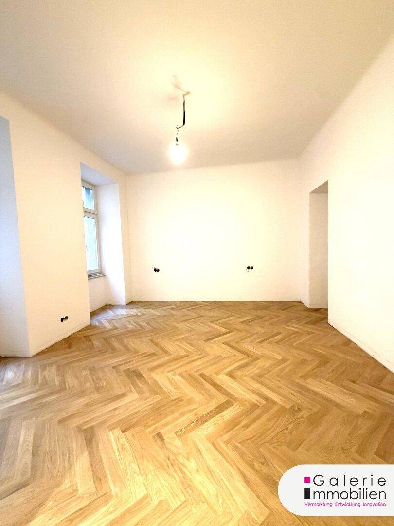 Geräumiges Zimmer mit klassischem Fischgrätparkett und viel Potenzial für neue Einrichtungsideen.
