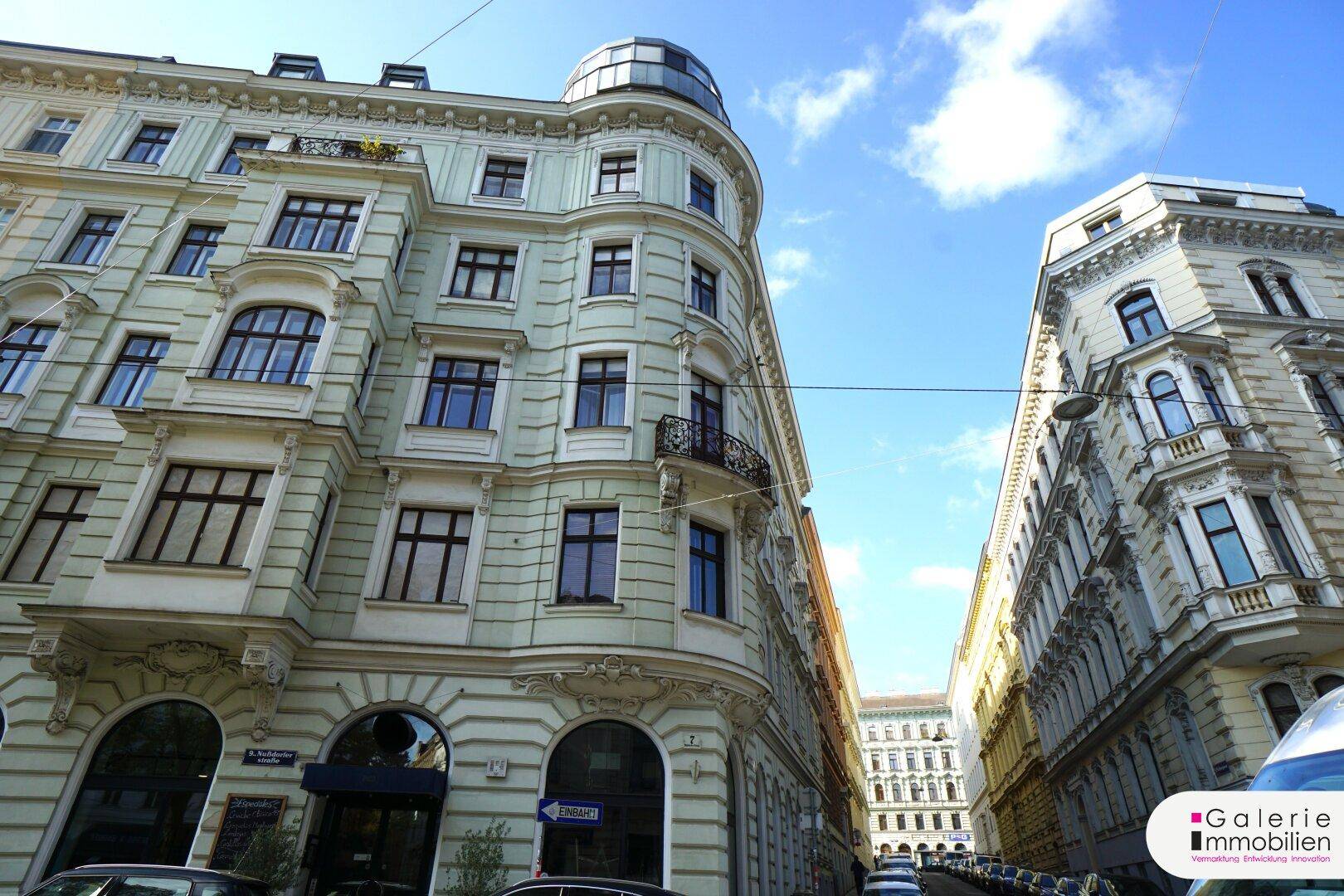 Historisches Eckgebäude mit klassischer Architektur und eleganten Details unter blauem Himmel.